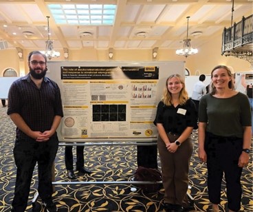 Three people posing with a research poster